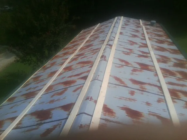 Rusted metal roof panels with new wood purlins before replacement — Storm Damage Roof Repair in Newfane by Roofing Brothers