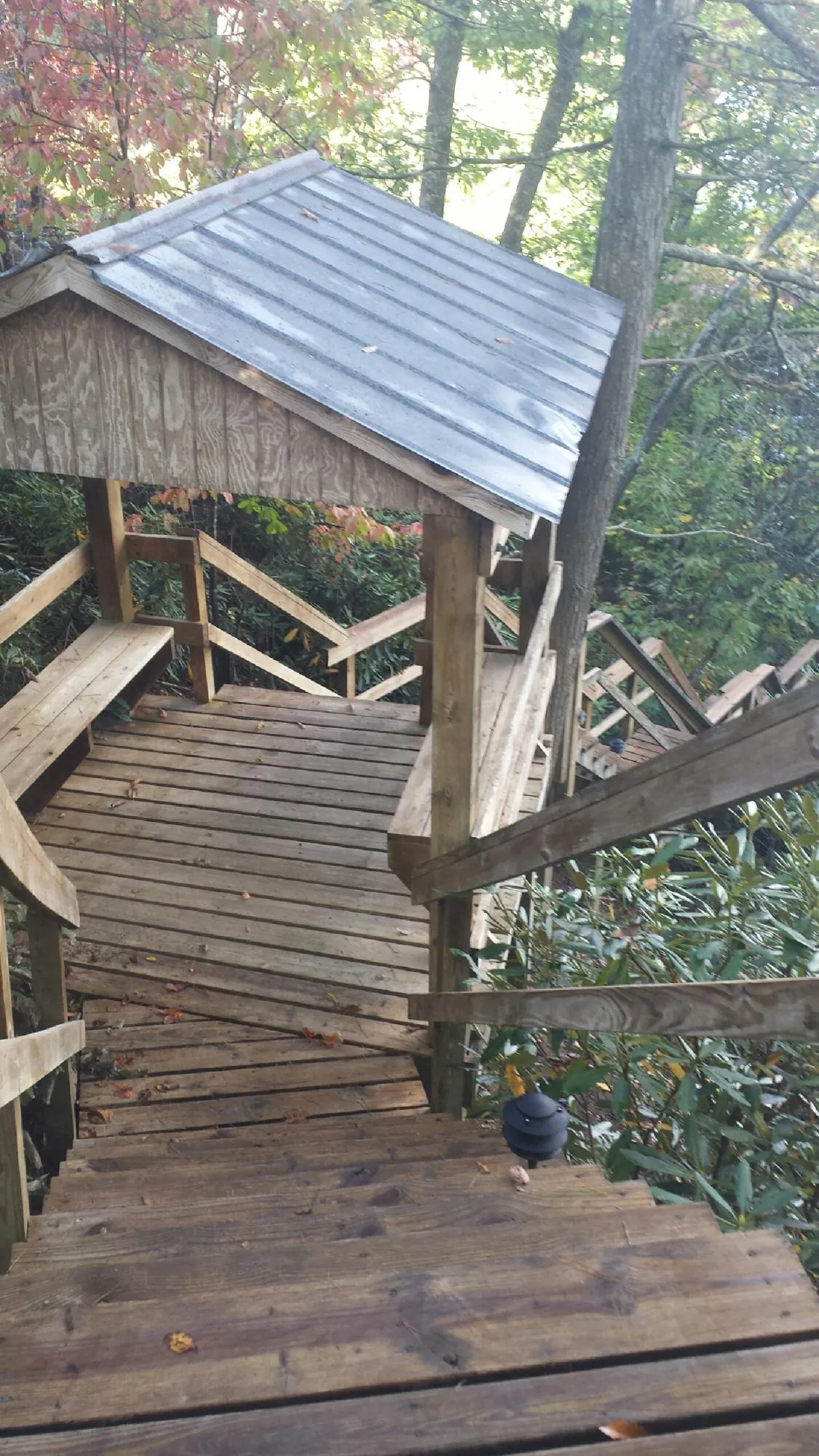 Metal roofed shelter over wooden steps on a wooded walkway — Skylight Repair & Installation work by our crew in Newfane